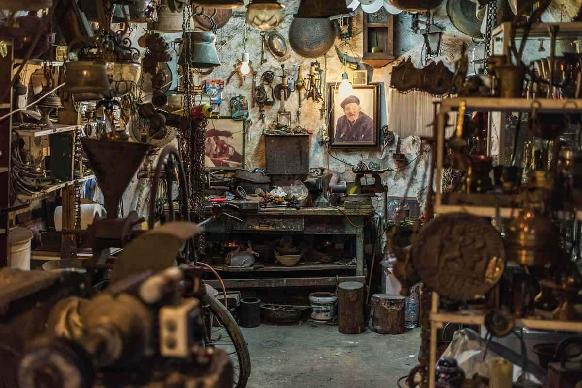 Un atelier vintage encombré d'outils, pièces métalliques, meubles et un portrait Un atelier vintage encombré d'outils, pièces métalliques, meubles et un portrait