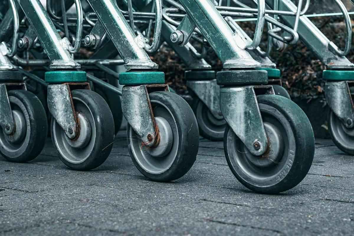 Plusieurs chariots métalliques alignés, leurs roues sur le béton Plusieurs chariots métalliques alignés, leurs roues sur le béton
