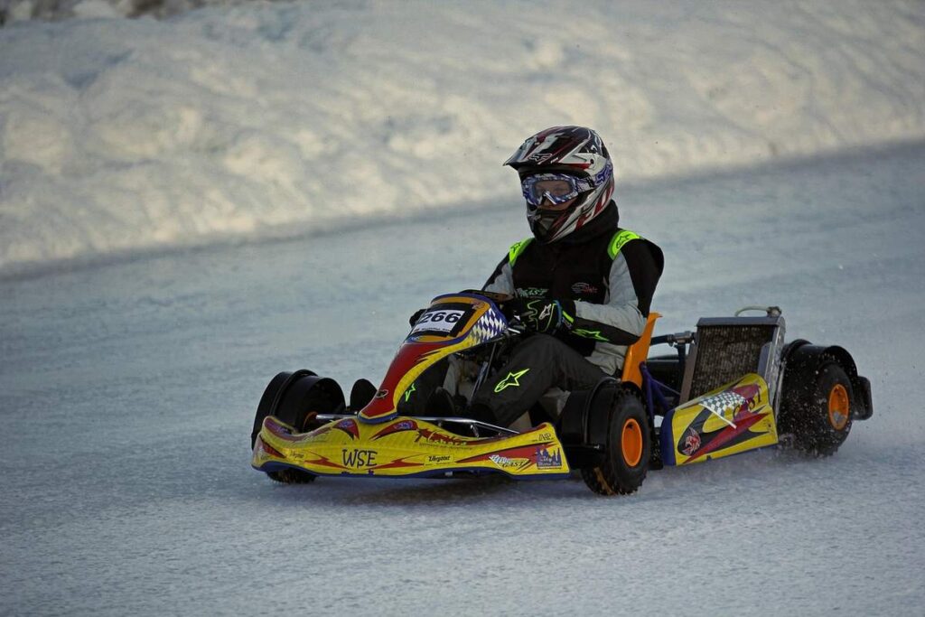 un kart jaune et noir glisse sur une surface glacée
