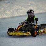 un kart jaune et noir glisse sur une surface glacée