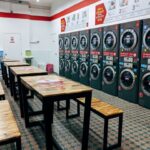 Laverie libre-service avec plusieurs lave-linge et un espace d'attente