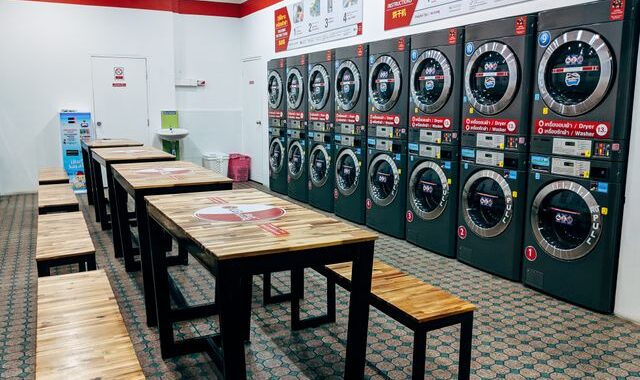 Laverie libre-service avec plusieurs lave-linge et un espace d'attente