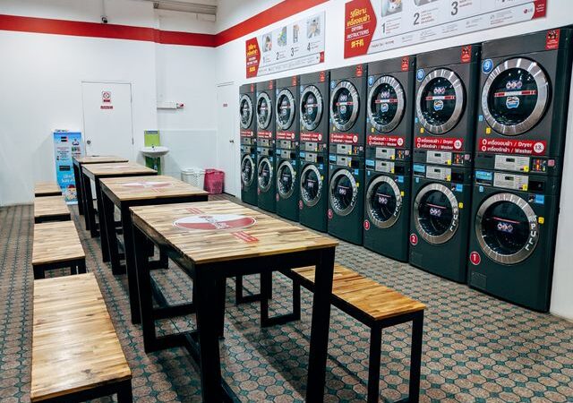 Laverie libre-service avec plusieurs lave-linge et un espace d'attente