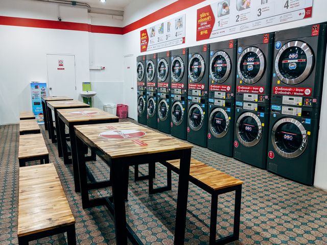 Laverie libre-service avec plusieurs lave-linge et un espace d'attente